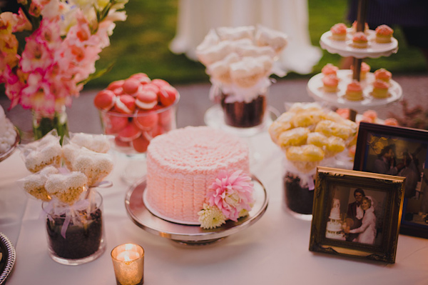Pretty and eclectic dessert table with pink cake and personal photos - Photo by Ryan Flynn Photography